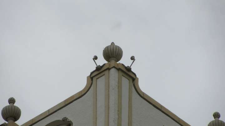 A close up view of a round decoration on the corner of the roof