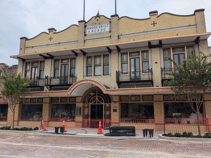 An ornately decorated 2-story shopping arcade made of sand-colored brick