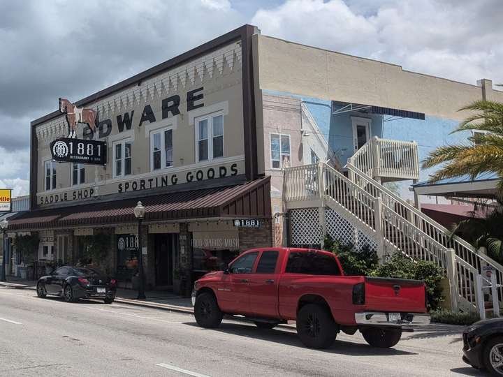 a tan 2-story building with brown trim & large stairs on the side.