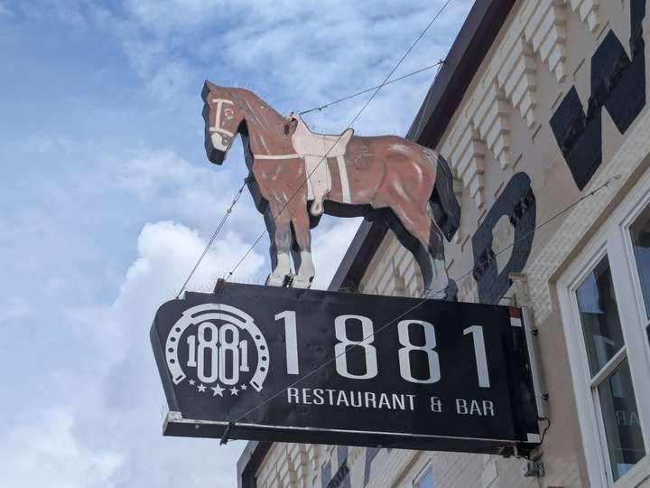 A sign for a restaurant with an illustrated horse on top