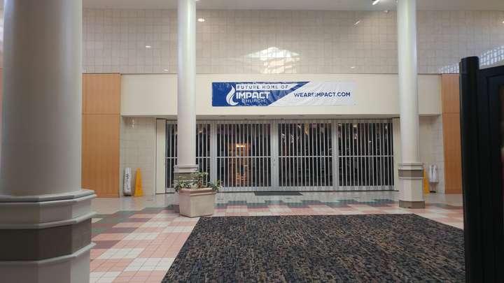 A department store storefront, framed by two columns