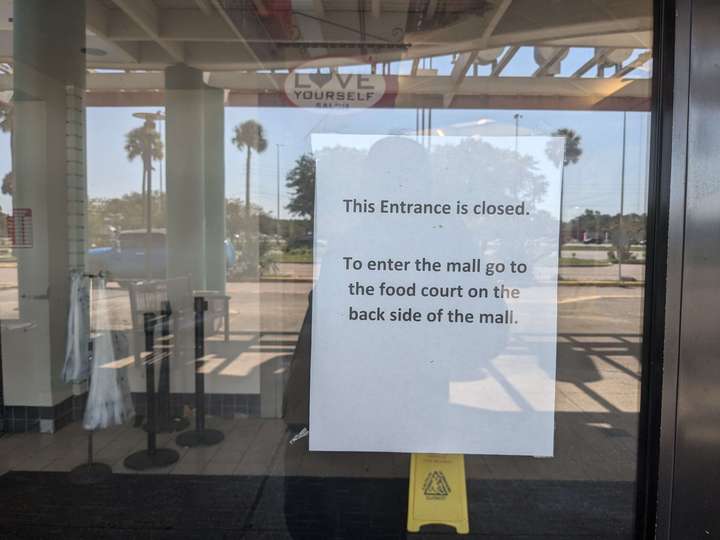 A paper 'entrance closed' notice taped to the inside of a glass door