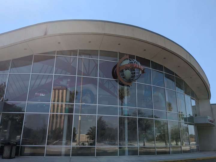 A large, curved glass front of a food court's exterior