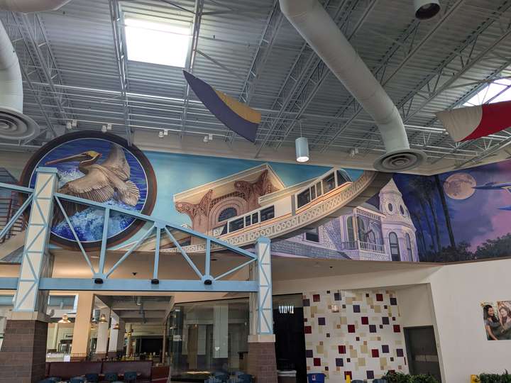 a mural on the upper wall of a food court depicting the JTA Skyway