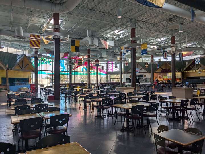 A view of an expansive, empty food court decorated with marine code flags