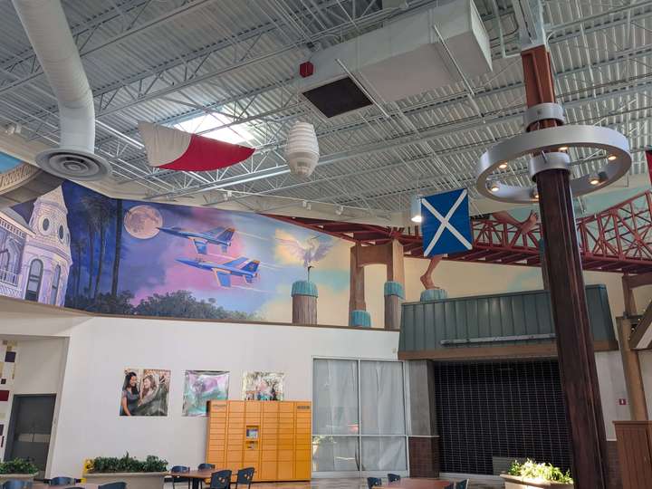 A mural on an upper wall depicting stylized Blue Angels jets