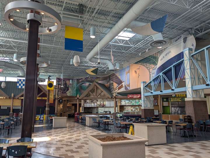 A view of food court stalls and a mural depicting a ship and bridges