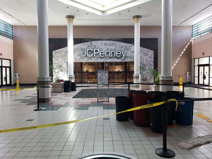 A marble and tile department store, framed by columns behind trashcans