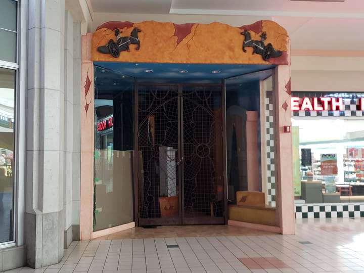 A vacant storefront with a ancient ruins themed facade