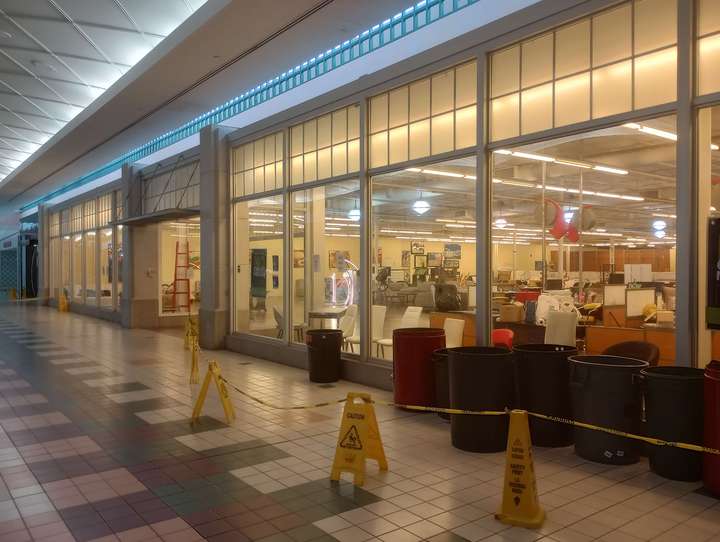 a warmly lit large storefront with large glass panel windows