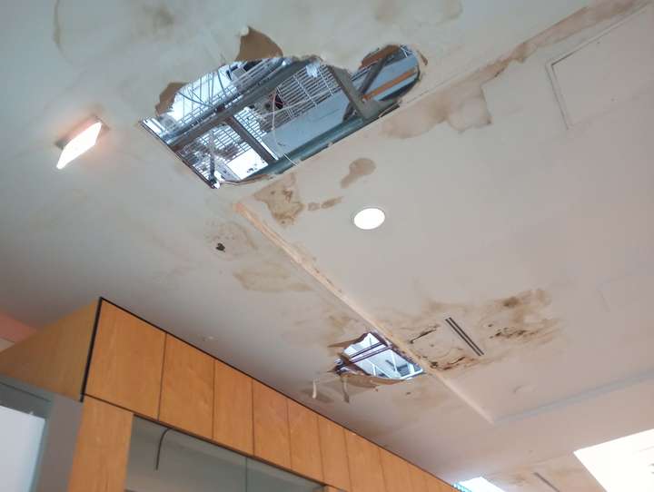 two holes in a mall ceiling; open sky is visible through them