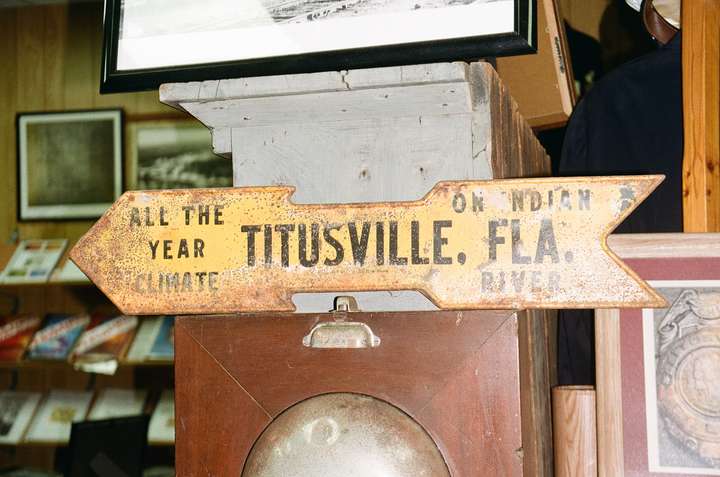 A small yellow arrow-shaped sign advertising Titusville, FL