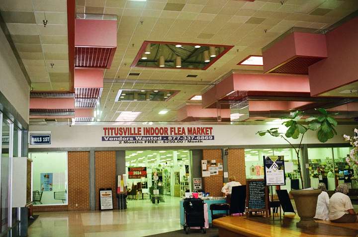 A warm-toned shot of a mall center court with pink roof decor