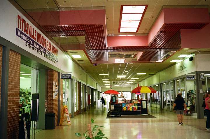 A warm-toned shot of a mall hallway with pink roof decor