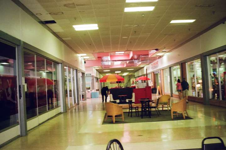 A blurred shot of a mall hallway with pink roof decor