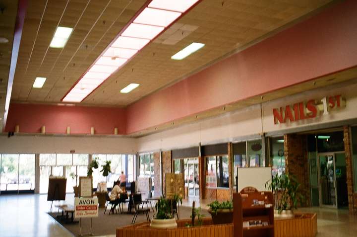 A blurred shot of a mall entryway with pink trim and a seating area