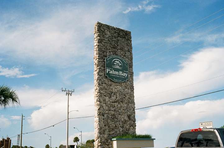 A tall slab covered in rock texture and a small sign