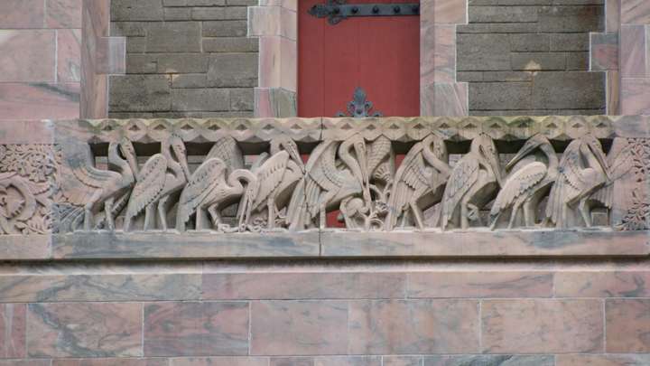 Intricately carved railings of herons with a crack in the middle