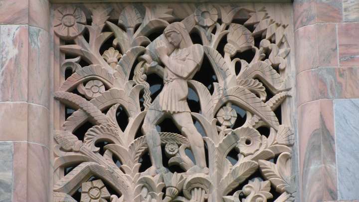 An art deco relief/cut-out of a man pouring water from a vessel surrounded by plants