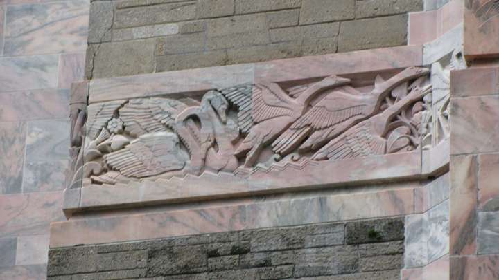 a relief carving of swans sitting and taking off