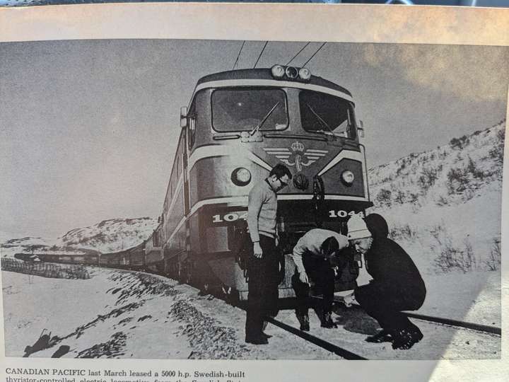 Canadian railway officials stand around a Swedish electric locomotive