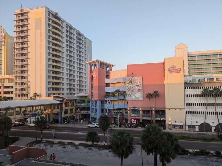 A view of a multi-story shopping center surrounded by condos and hotels