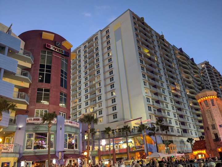 A view of a movie theater and hotel tower at dusk