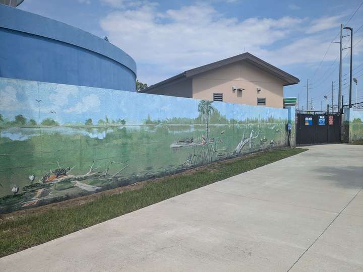 A mural of marshland on a concrete fence