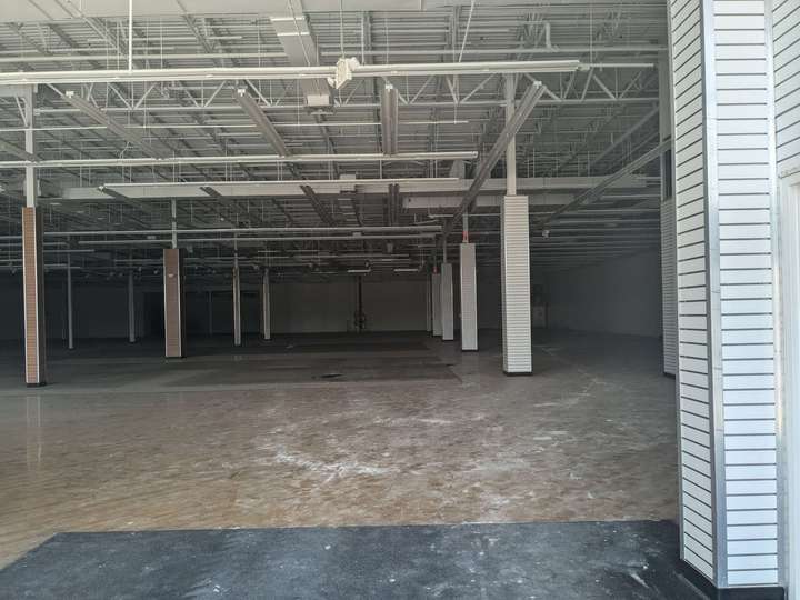 A totally empty store interior, only pillars, a concrete floor, and ceiling are visible