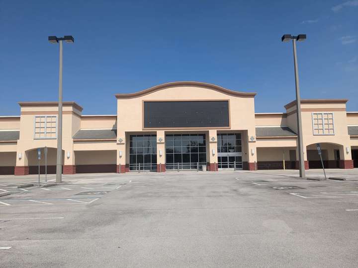 A large vacant store with a scalloped facade