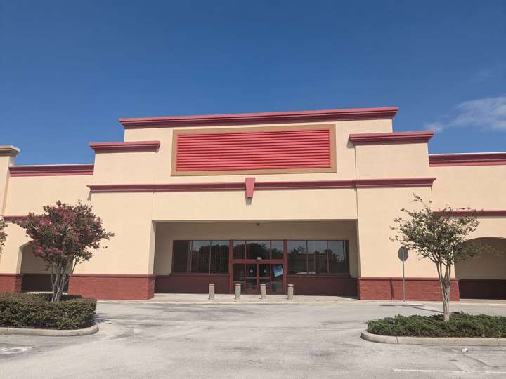 A vacant storefront with a red rectangle that used to be the sign