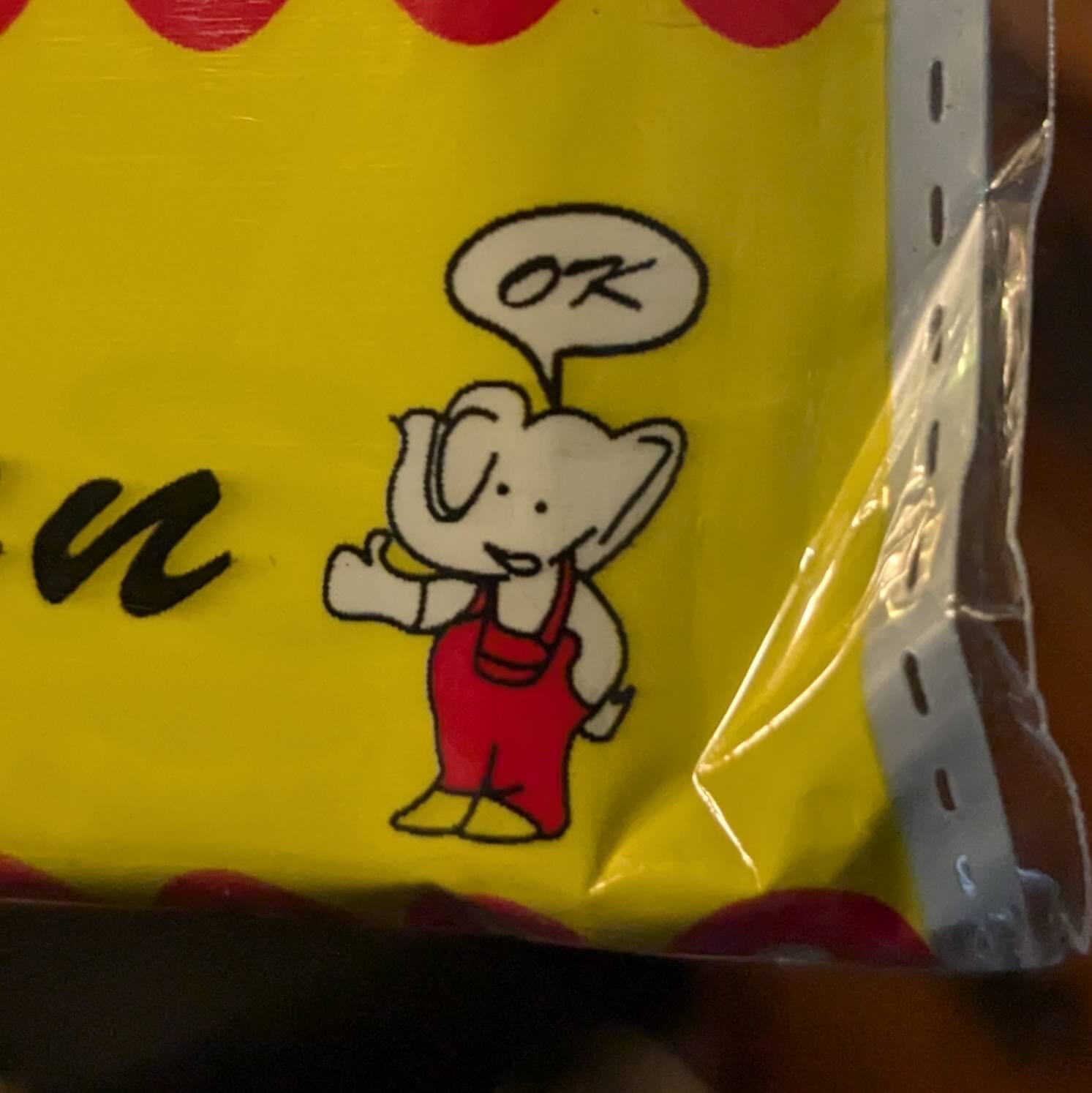 A small white cartoon elephant in red overalls saying "OK" with a thumbs up