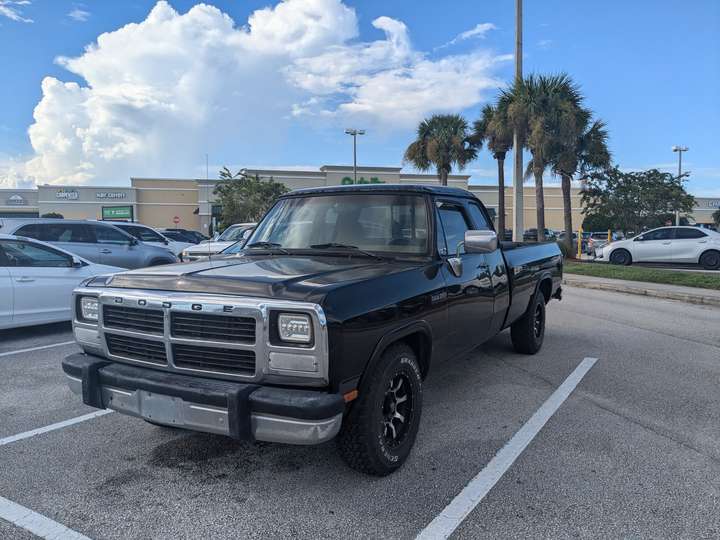 A black extended cab pickup truck with a silver grille