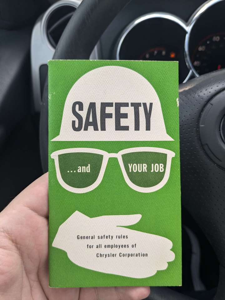 a green cover design of a hard hat, glasses, and glove