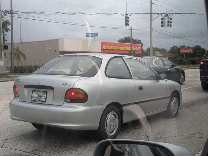 A small silver economy coupe in traffic