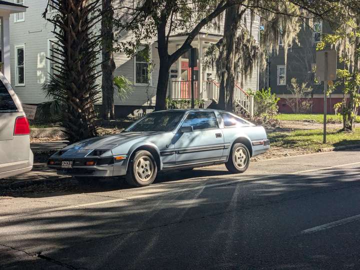 a street parked silver-blue Nissan sports car