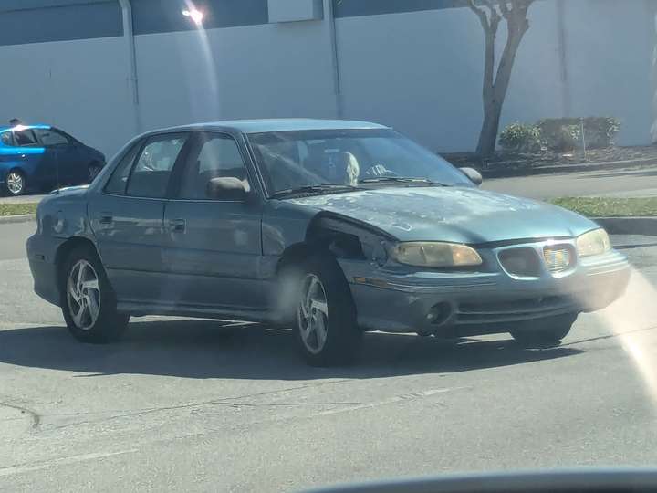 a blue sedan with a damaged front quarter panel