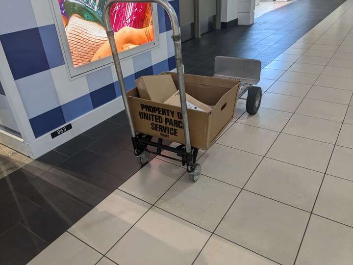 a mail crate on a cart that says United Parcel Service