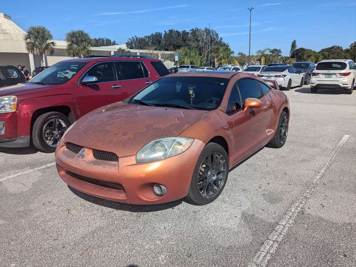 A weathered metallic orange sports car