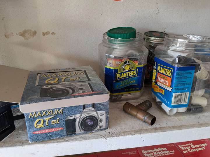 A camera box next to two empty peanut jars used to hold misc items