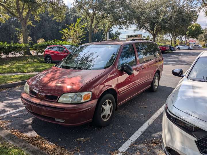 a red luxury minivan with a broken wing mirror