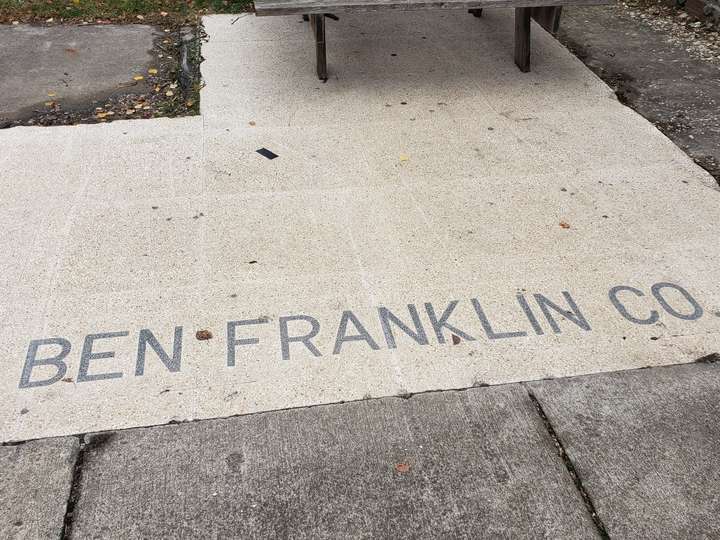 Ben Franklin Co. is spelled out in simple dark gray text against a beige backing