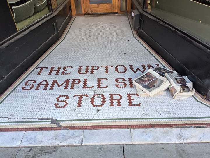 THE UPTOWN SAMPLE SHOE STORE is spelled in red hexagonal tiles against a white background