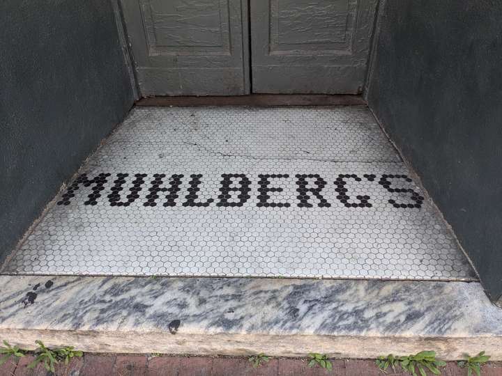 the word MUHLBERG'S spelled out with simple hexagonal tiles