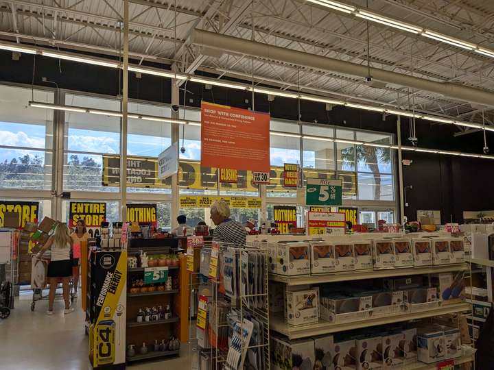 a view inside a store, looking towards glass windows at the front over some shelves