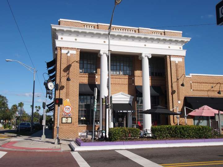 A orange brick bank building with white columns and trim