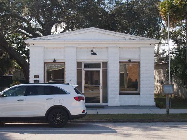 a small, one story brick building painted entirely white, with a center door and windows on either side