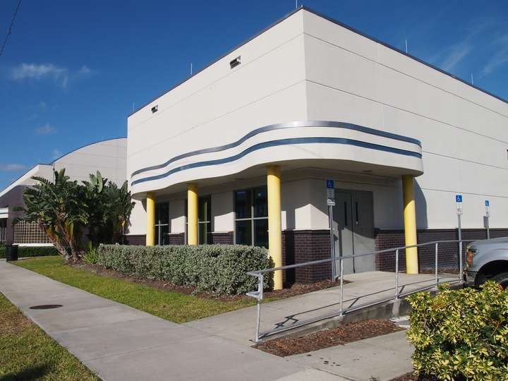 Another curved canopy, with blue accents supported by yellow columns on the building's corner