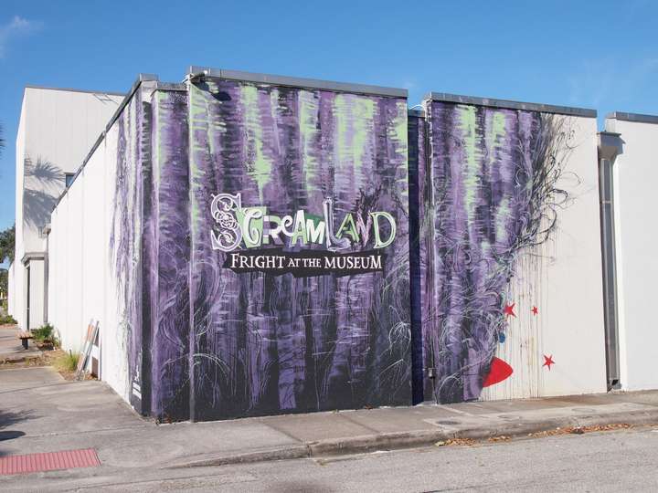 A purple mural advertising a haunted house