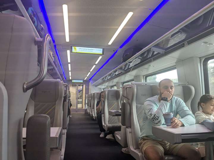 The interior of a modern passenger train in daylight